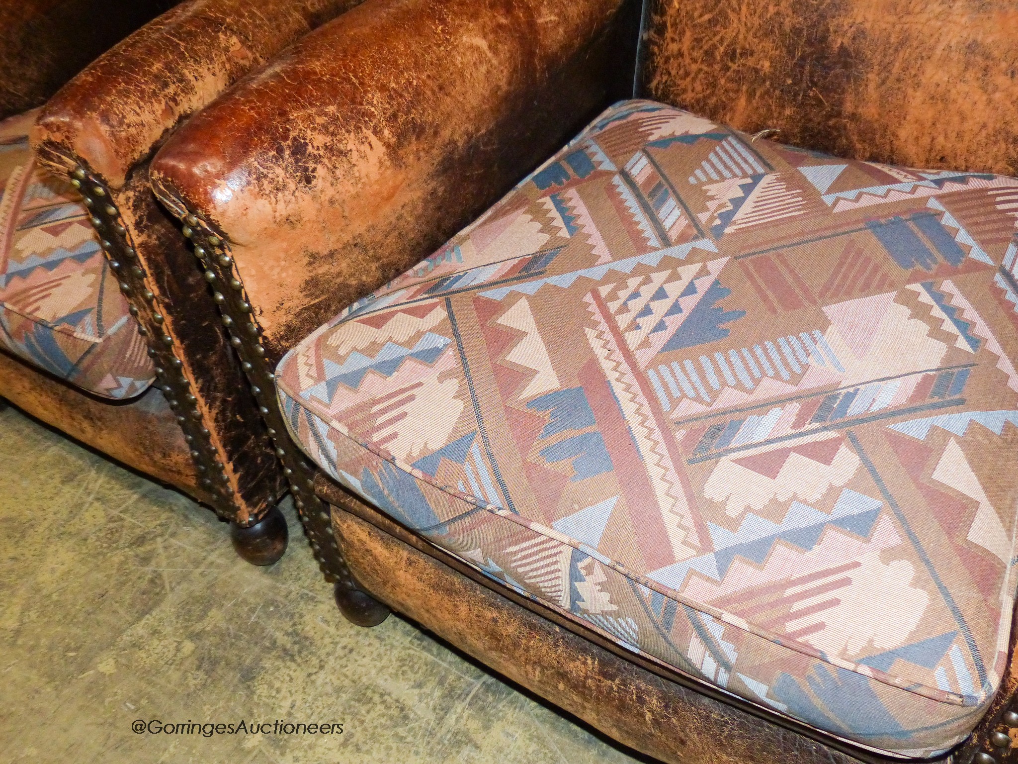 A pair of tan leather upholstered armchairs, width 70cm, depth 80cm, height 85cm